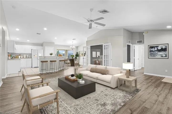 Living area featuring lofted ceiling, french doors, recessed lighting, a ceiling fan, and light wood-style flooring
