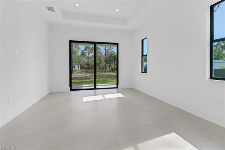Tiled spare room featuring a raised ceiling