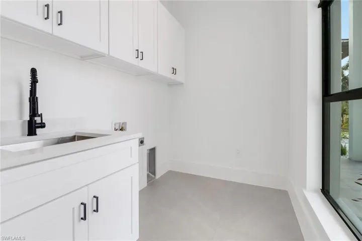 Laundry area featuring electric dryer hookup, cabinets, sink, and hookup for a washing machine