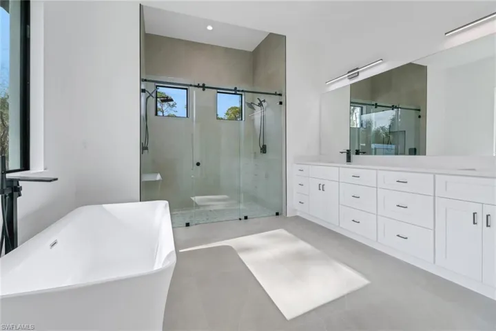 Bathroom featuring vanity and separate shower and tub