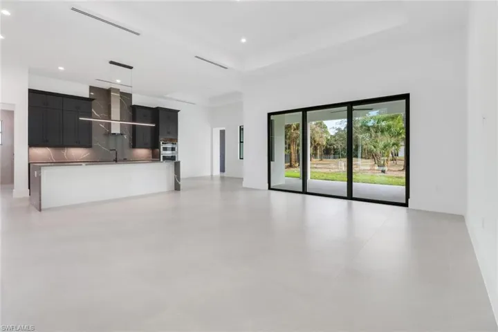 Unfurnished living room featuring sink and a tray ceiling