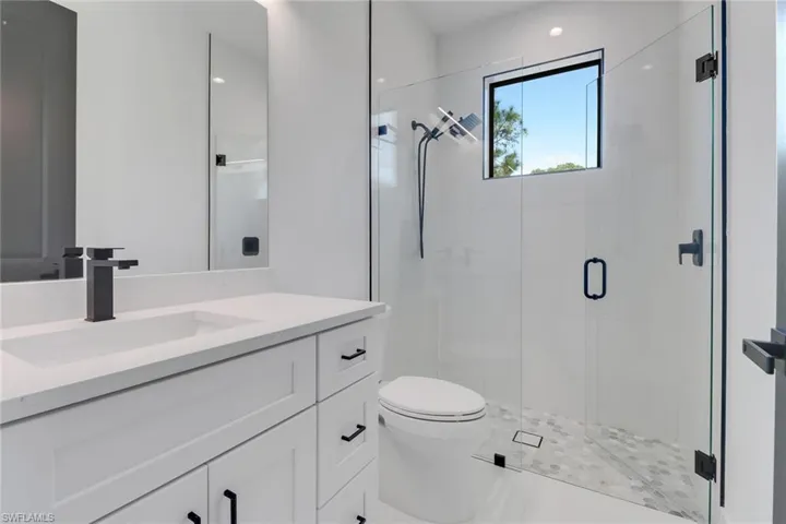 Bathroom with vanity, toilet, and an enclosed shower
