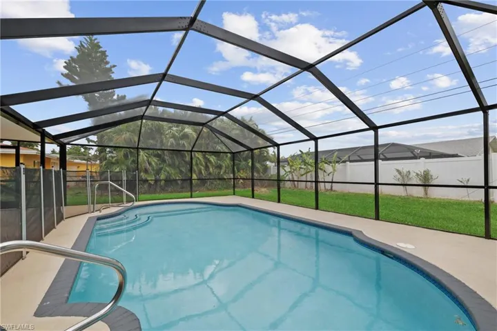View of swimming pool with a yard and glass enclosure
