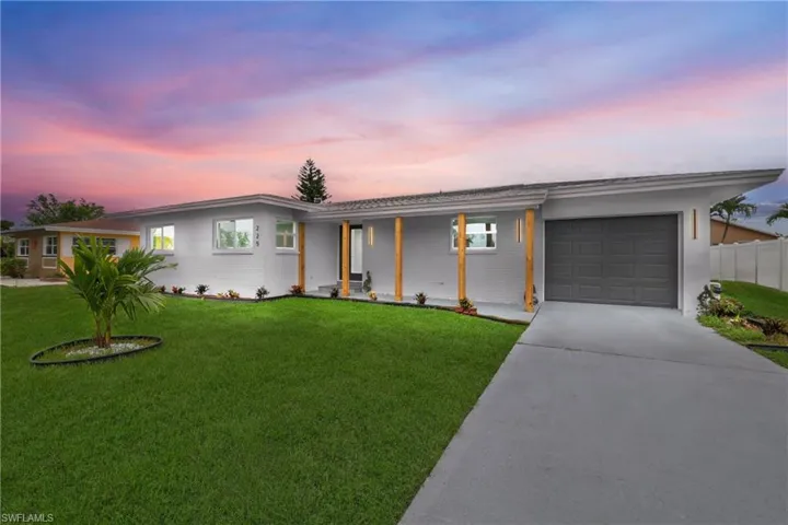 Ranch-style house featuring a garage and a yard