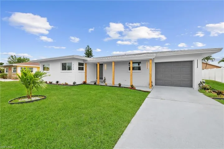 Ranch-style home featuring a garage and a front yard