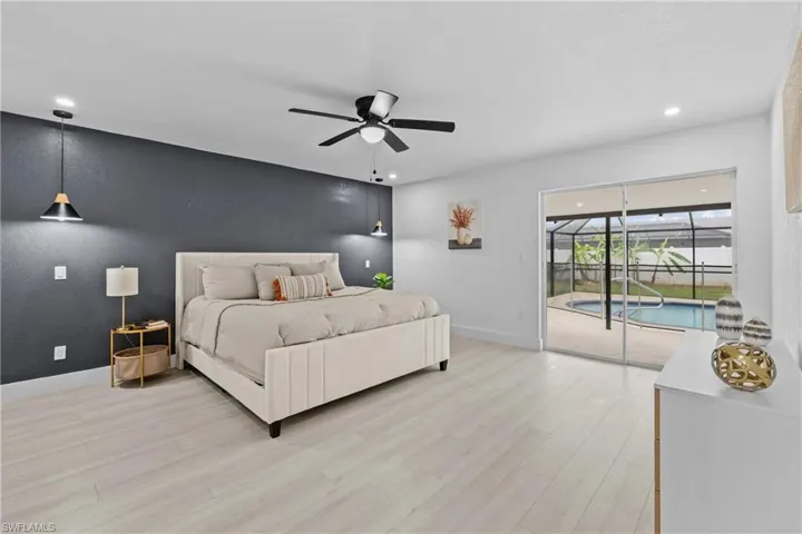 Bedroom with light hardwood / wood-style floors, ceiling fan, and access to outside