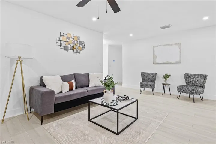Living room with ceiling fan and light hardwood / wood-style flooring