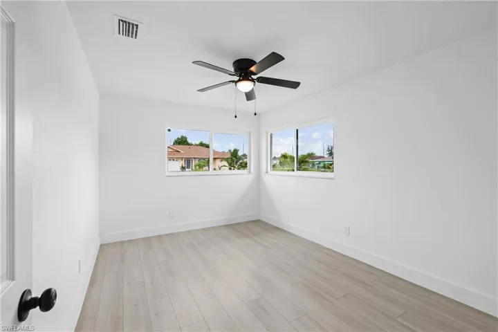 Empty room with ceiling fan and light wood-type flooring