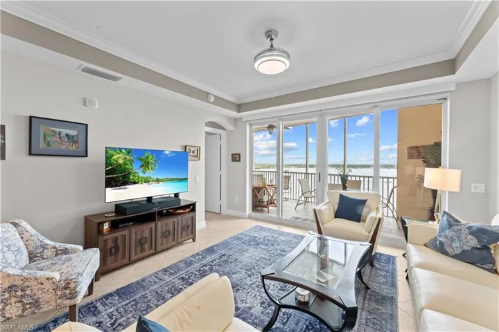 Tiled living room featuring crown molding