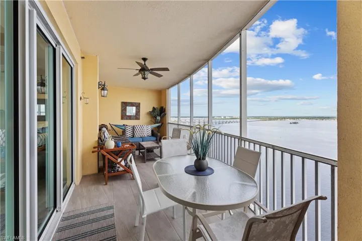 Sunroom / solarium with a water view and ceiling fan