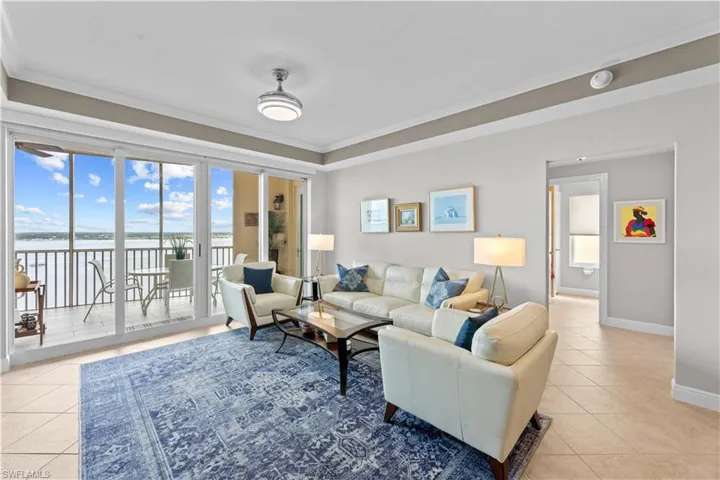 Living room featuring ornamental molding, a water view, and light tile patterned floors