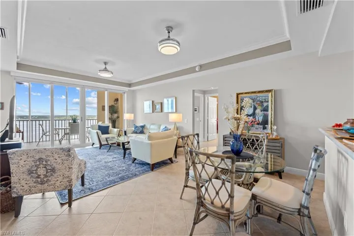 Tiled dining space with crown molding and a tray ceiling