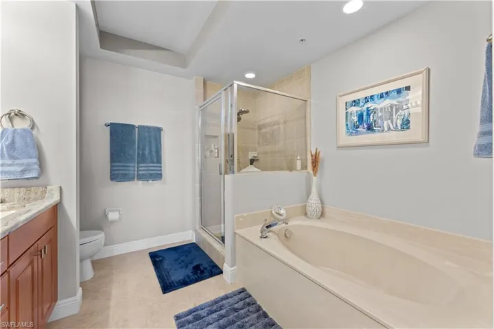 Full bathroom with vanity, toilet, tile patterned flooring, and shower with separate bathtub