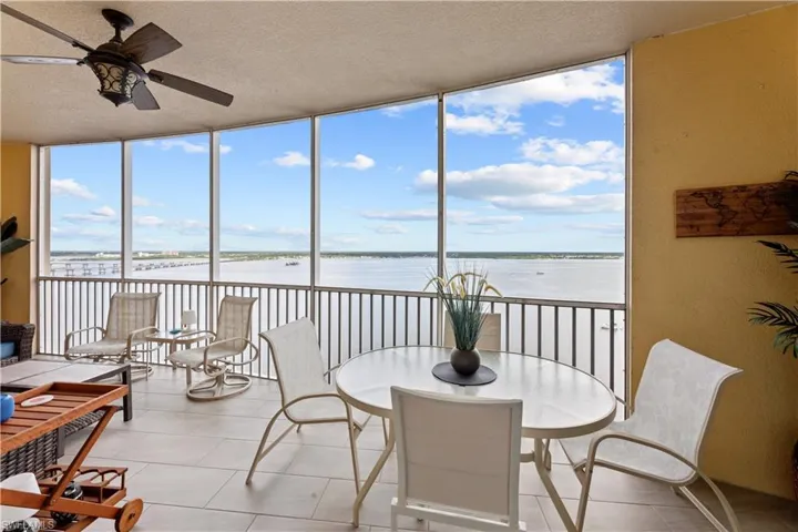 Sunroom / solarium featuring a water view and ceiling fan
