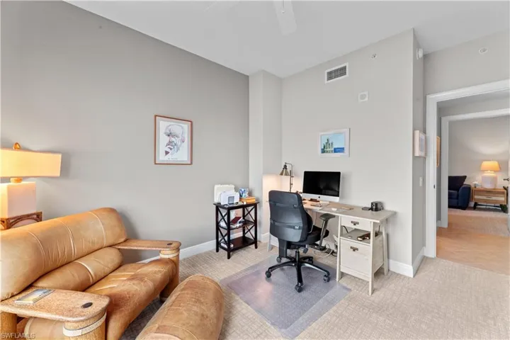 Carpeted office featuring ceiling fan