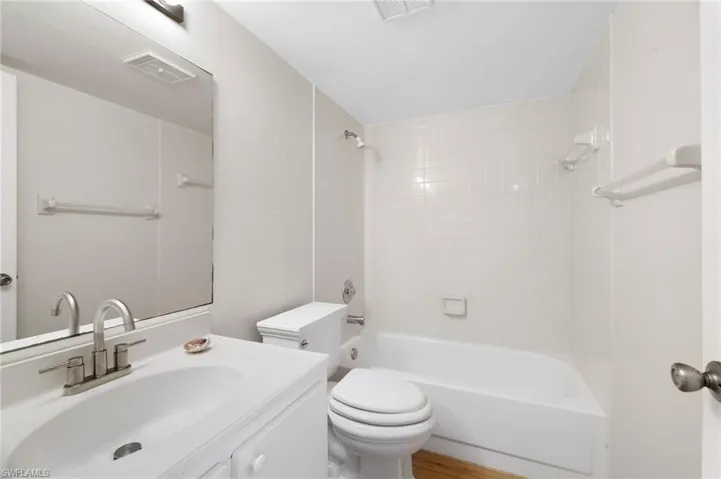 Full bath with vanity,  shower combination, and wood finished floors