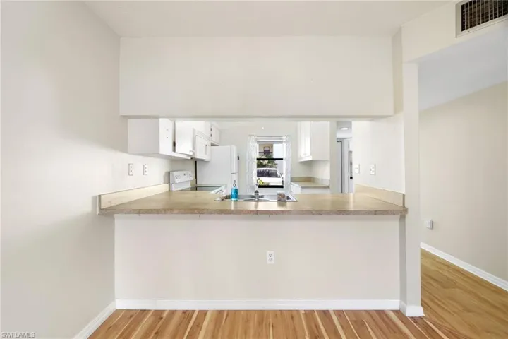 Kitchen with white cabinets, light countertops, and light wood finished floors