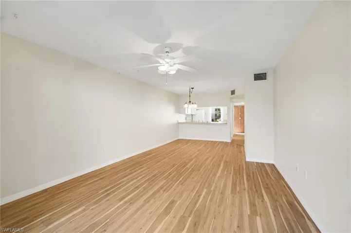 Unfurnished living room with light wood-type flooring and ceiling fan