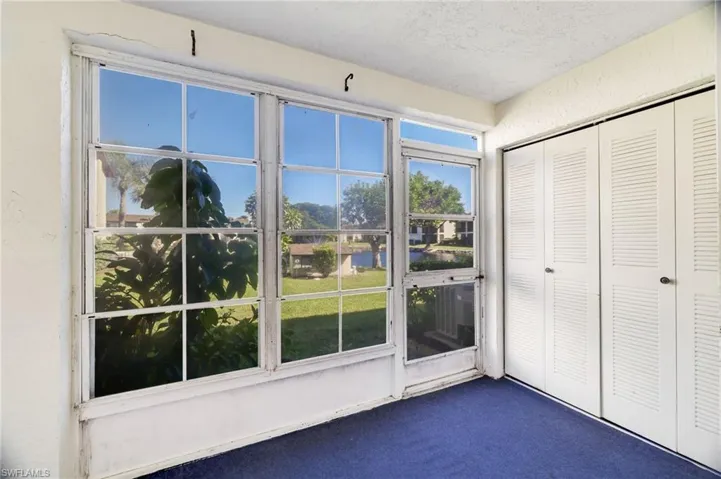 Doorway featuring carpet, a textured ceiling, a textured wall, and a water view