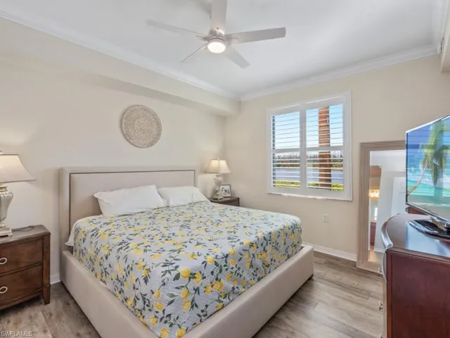 Bedroom featuring crown molding, light wood-style flooring, baseboards, and ceiling fan