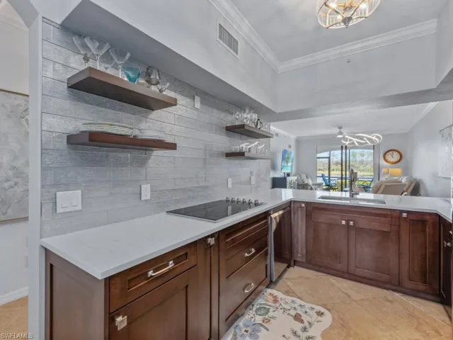Kitchen with visible vents, ornamental molding, a sink, open shelves, and black electric cooktop