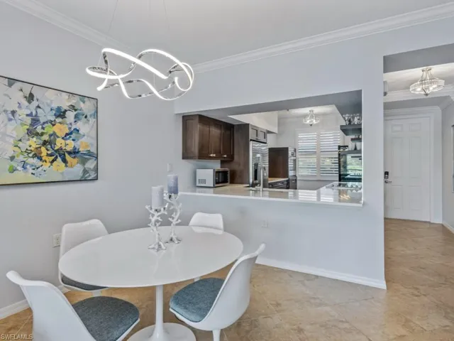 Dining space featuring crown molding, an inviting chandelier, baseboards, and light tile patterned floors