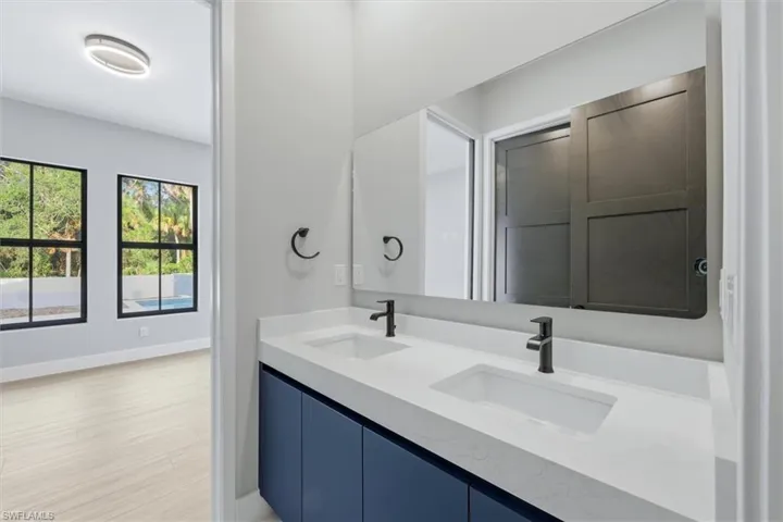Dual vanity with integrated sinks, white countertop, and matte black fixtures