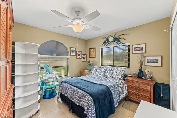 Bedroom with ceiling fan and light tile patterned floors