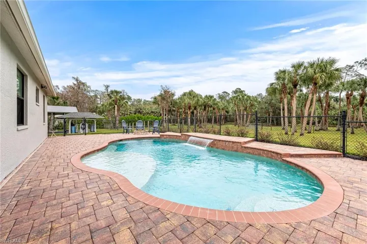 View of swimming pool with a patio and pool water feature
