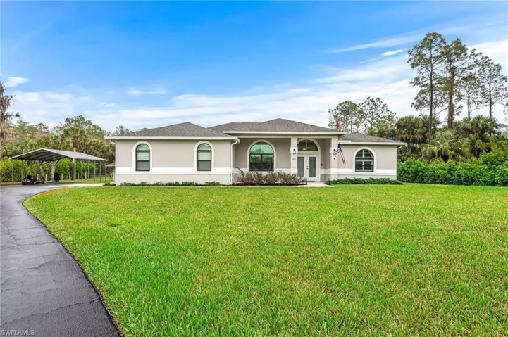 View of front facade with a front yard and a carport