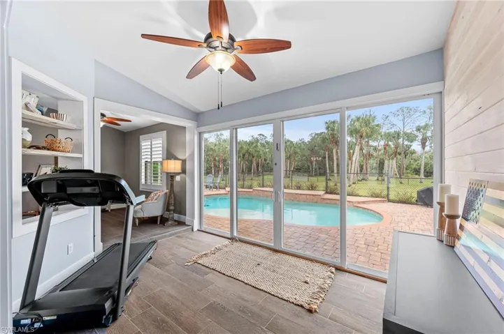 Workout area featuring built in shelves and vaulted ceiling