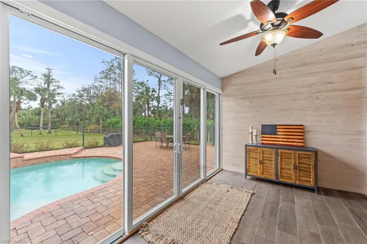 Unfurnished sunroom featuring vaulted ceiling and ceiling fan