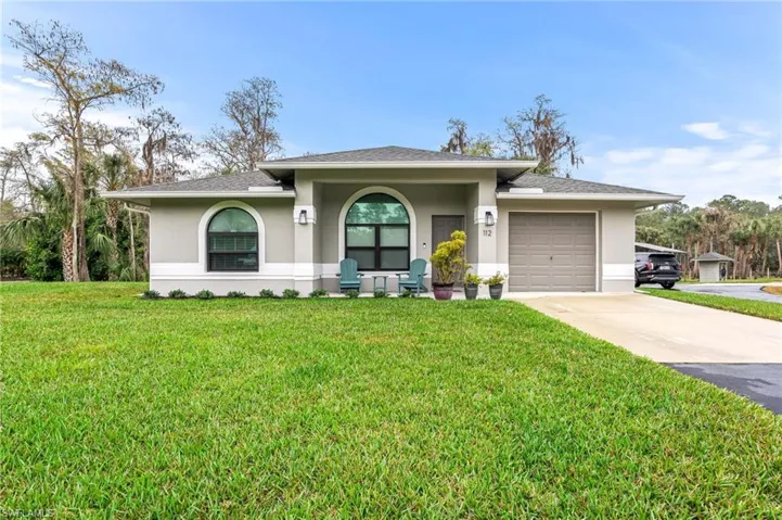 View of front facade with a garage and a front lawn
