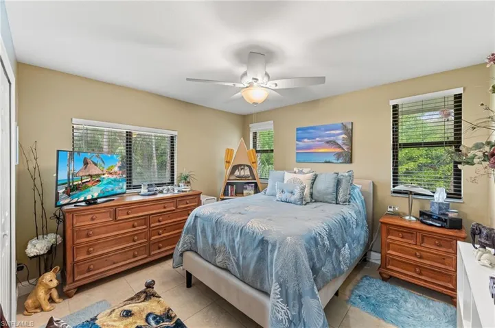 Bedroom with ceiling fan and light tile patterned flooring