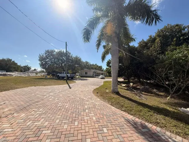 View of home's driveway with a yard & gate