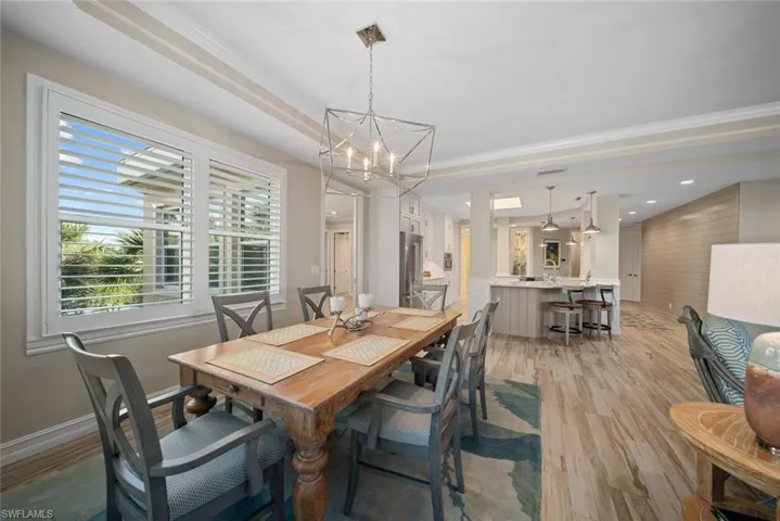 Dining room featuring light hardwood / wood-style floors, crown molding, and a notable chandelier