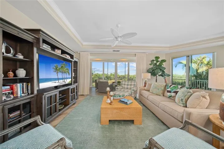 Living room with ceiling fan, crown molding, a wealth of natural light, and light hardwood / wood-style flooring