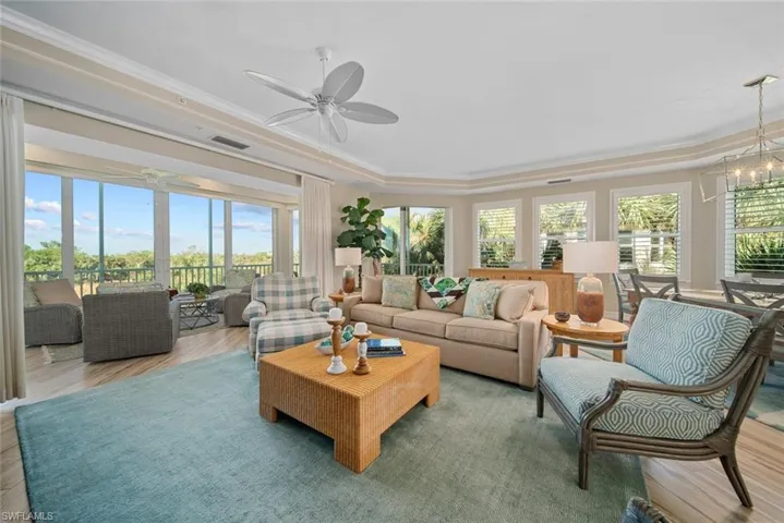 Sunroom with ceiling fan with notable chandelier