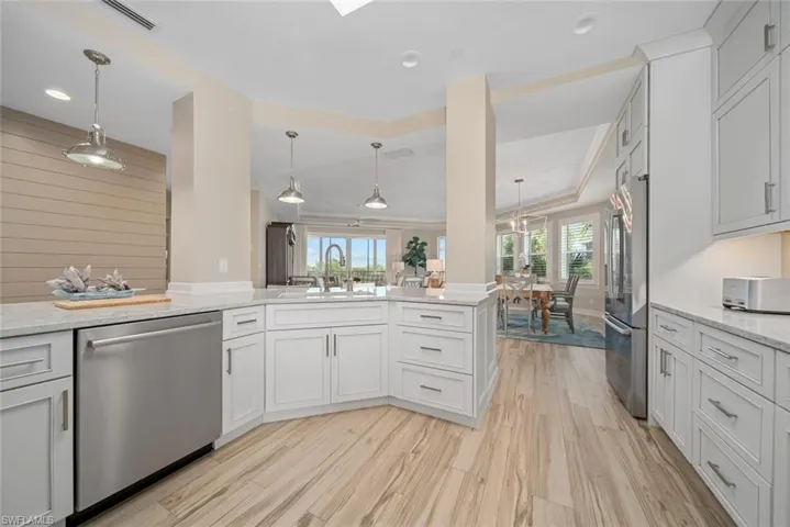 Kitchen with white cabinets, sink, light wood-type flooring, and stainless steel appliances
