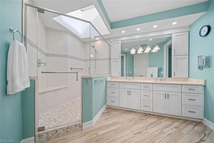 Bathroom featuring hardwood / wood-style floors, vanity, and a shower with shower door