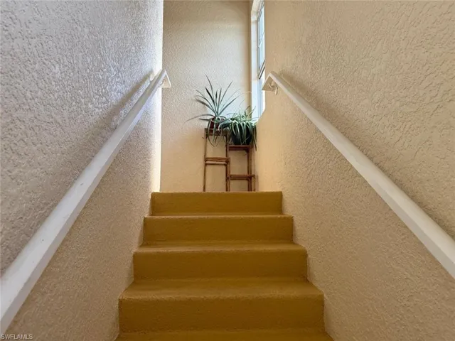 Staircase featuring a textured wall