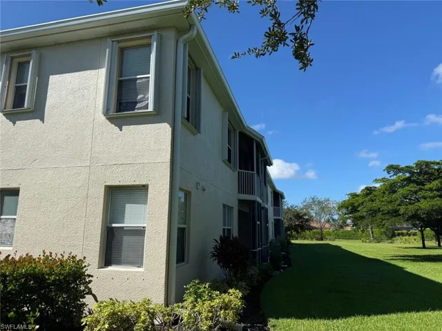 View of property exterior featuring a lawn and stucco siding
