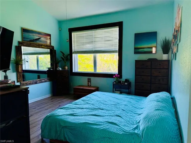 Bedroom with multiple windows and wood finished floors