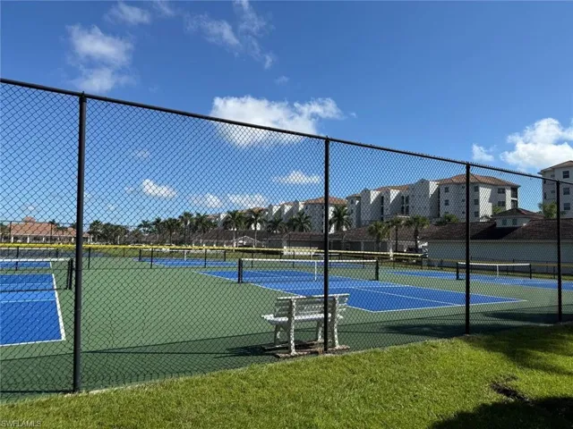 View of tennis court with a residential view
