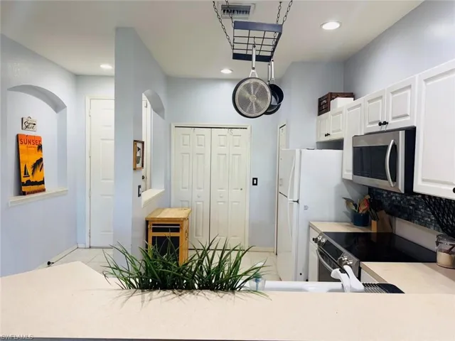 Kitchen with appliances with stainless steel finishes, white cabinets, light countertops, recessed lighting, and light tile patterned floors