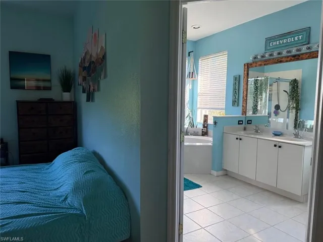 Bedroom featuring light tile patterned flooring and a sink