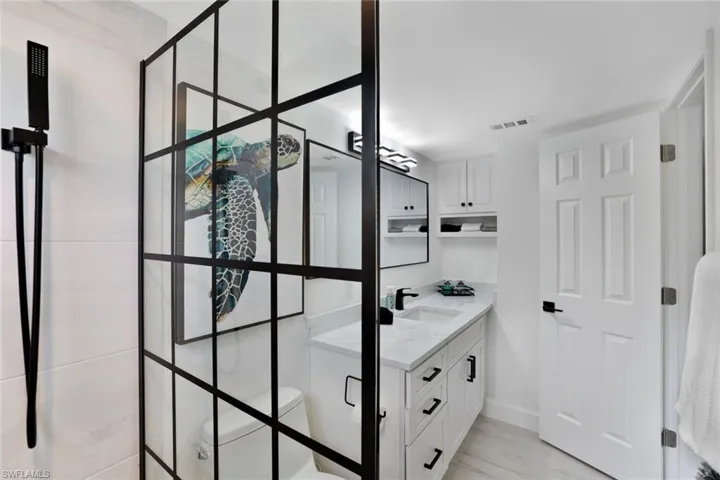Beautifully renovated bathroom featuring a modern glass shower enclosure and clean lines.