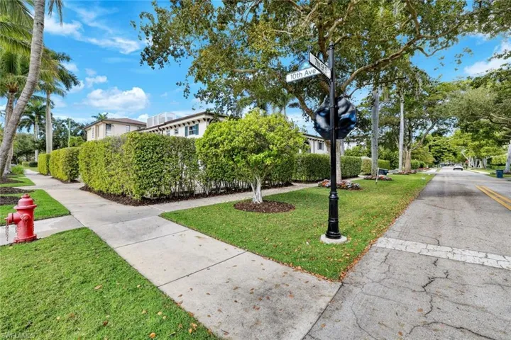 Charming neighborhood setting with shaded walking paths and lush greenery.