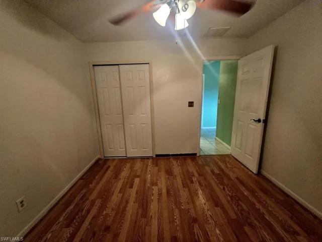 Unfurnished bedroom featuring ceiling fan, hardwood / wood-style floors, and a closet