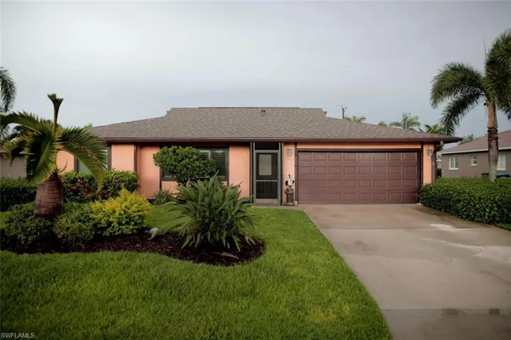 Ranch-style house featuring a garage and a front yard